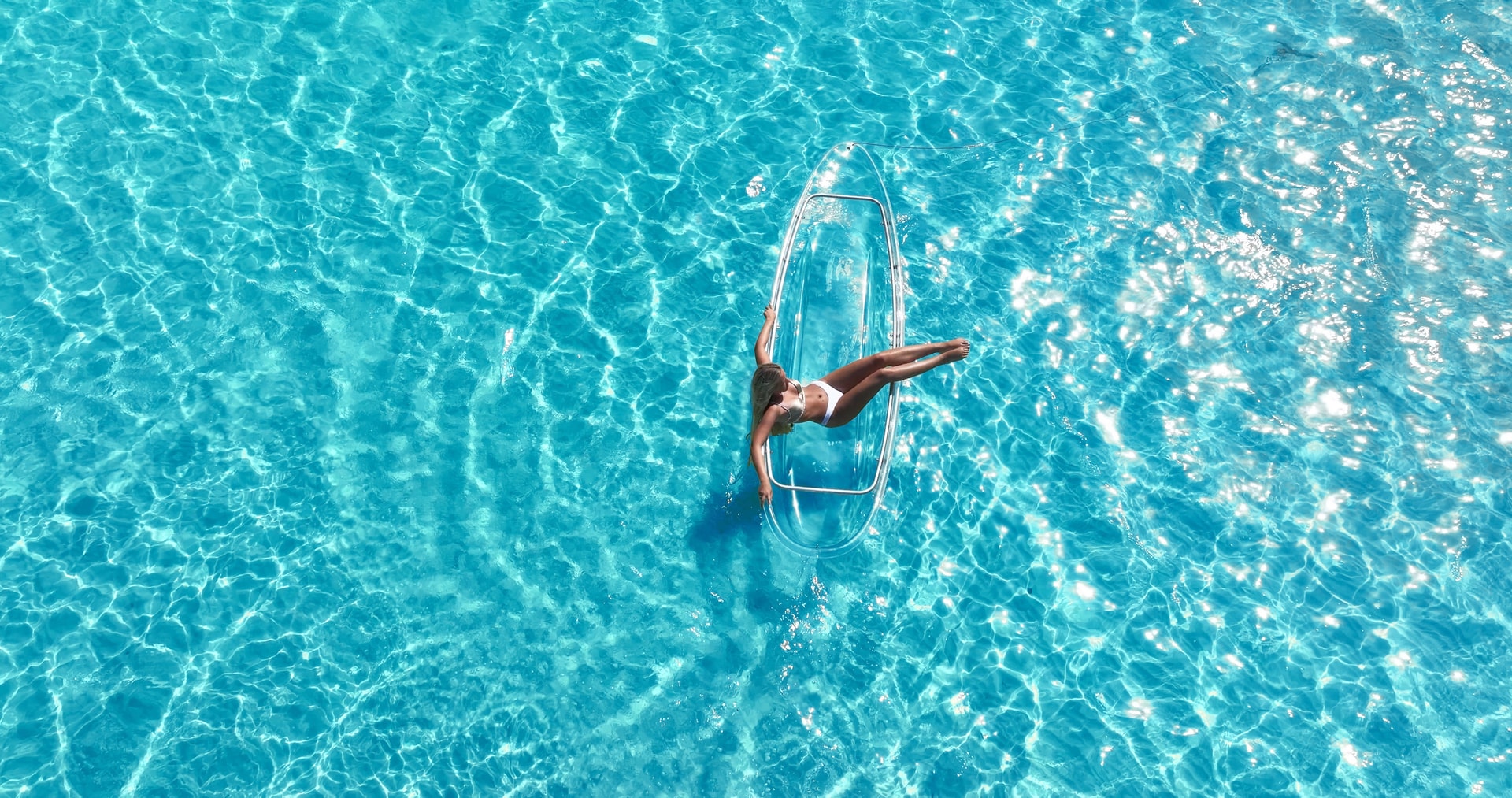 Aerial drone view of a woman on a clear kayak in Aruba